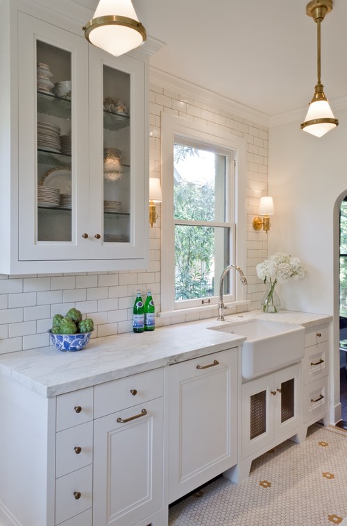 White kitchen with farmhouse sink and wall cabinet beside a window—ideal example for scribing a filler panel to a wavy wall after shimming the cabinet plumb