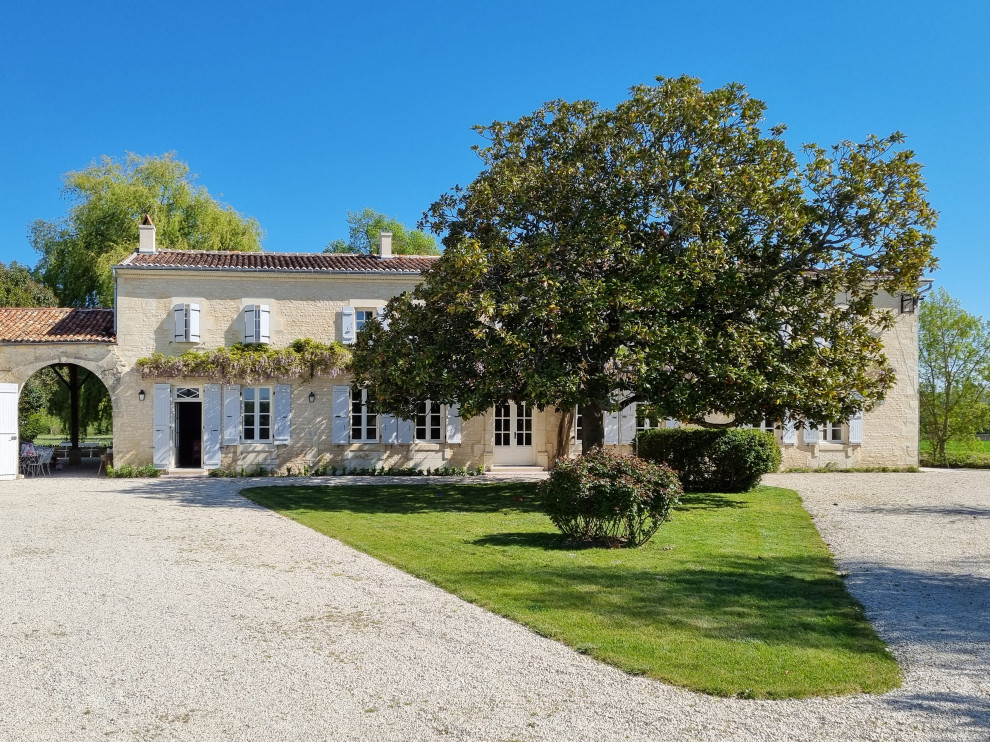 Großes, Zweistöckiges Landhausstil Einfamilienhaus mit Steinfassade, beiger Fassadenfarbe, Walmdach, Ziegeldach und rotem Dach in Bordeaux