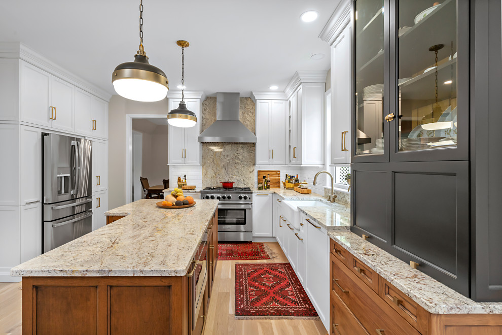Enclosed kitchen - mid-sized traditional l-shaped light wood floor and beige floor enclosed kitchen idea in Philadelphia with a farmhouse sink, recessed-panel cabinets, granite countertops, white backsplash, ceramic backsplash, stainless steel appliances, an island and multicolored countertops