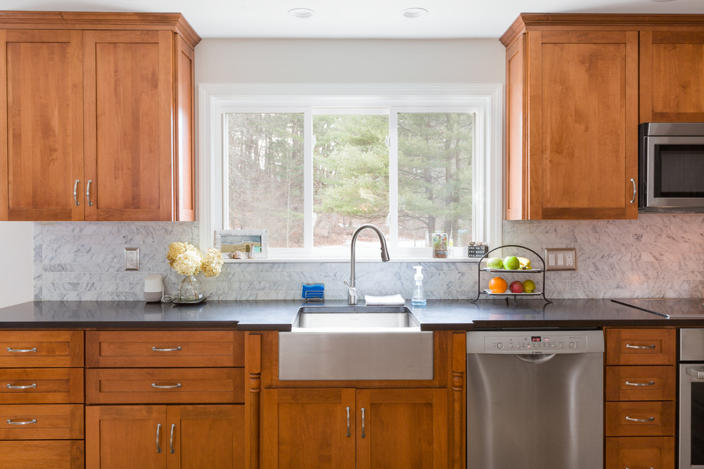 Photo of a mid-sized transitional u-shaped eat-in kitchen in Boston with a farmhouse sink, beaded inset cabinets, medium wood cabinets, marble benchtops, grey splashback, marble splashback, stainless steel appliances, medium hardwood floors, a peninsula and grey benchtop.