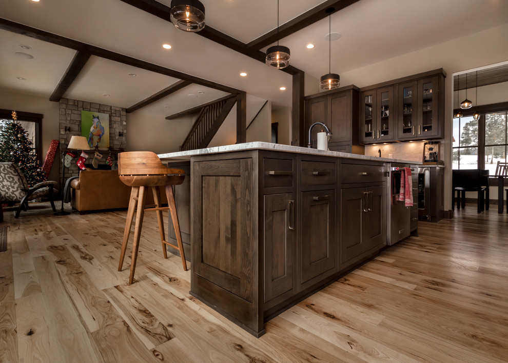 Inspiration for a large rustic l-shaped light wood floor and beige floor open concept kitchen remodel in Denver with an undermount sink, shaker cabinets, dark wood cabinets, quartz countertops, beige backsplash, subway tile backsplash, stainless steel appliances, an island and white countertops