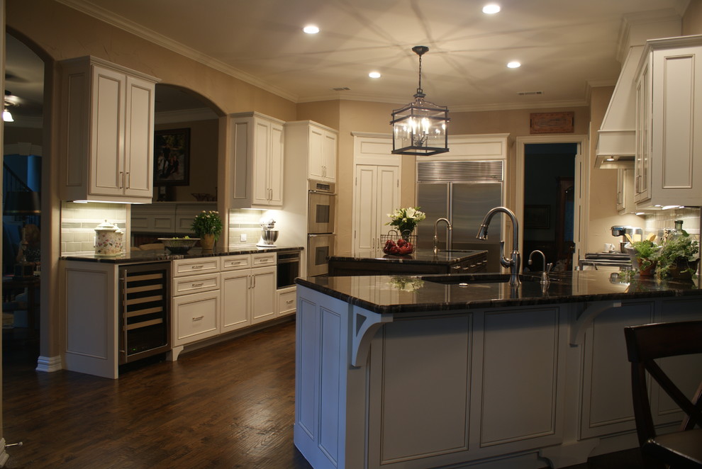 Inspiration for a large transitional u-shaped medium tone wood floor kitchen remodel in Dallas with an undermount sink, flat-panel cabinets, white cabinets, granite countertops, green backsplash, ceramic backsplash, stainless steel appliances and beige walls