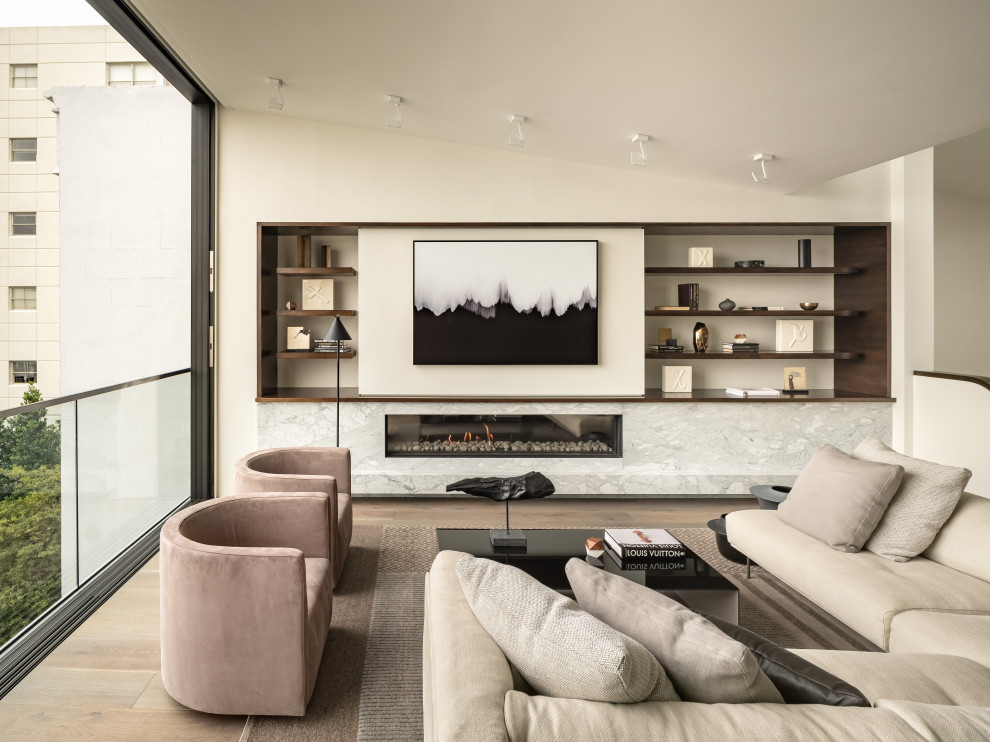 This is an example of a contemporary open concept living room in San Francisco with white walls, medium hardwood floors, a ribbon fireplace and brown floor.