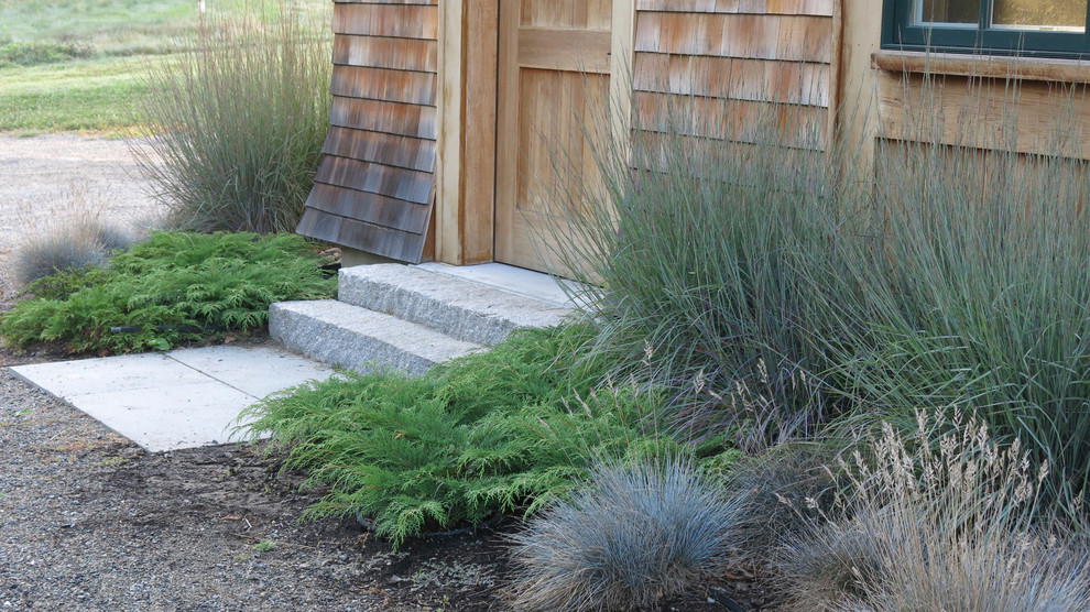 This is an example of a mid-sized rustic full sun front yard stone landscaping in Boston for summer.