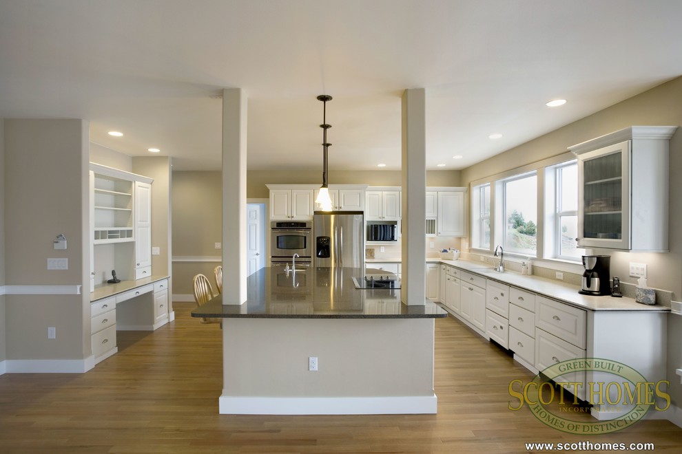 Design ideas for a large arts and crafts l-shaped open plan kitchen in Seattle with beaded inset cabinets, white cabinets, granite benchtops, stainless steel appliances, light hardwood floors and with island.