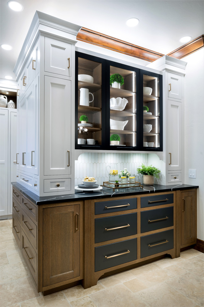 Inspiration for a large country l-shaped separate kitchen in Oklahoma City with an undermount sink, white cabinets, quartz benchtops, white splashback, porcelain splashback, panelled appliances, marble floors, with island and black benchtop.