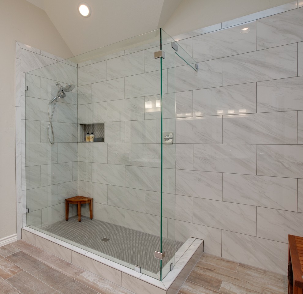 Design ideas for a mid-sized modern 3/4 wet room bathroom in Dallas with furniture-like cabinets, white cabinets, a two-piece toilet, gray tile, porcelain tile, beige walls, porcelain floors, an undermount sink, marble benchtops, beige floor, an open shower, a shower seat, a double vanity, a freestanding vanity and white benchtops.
