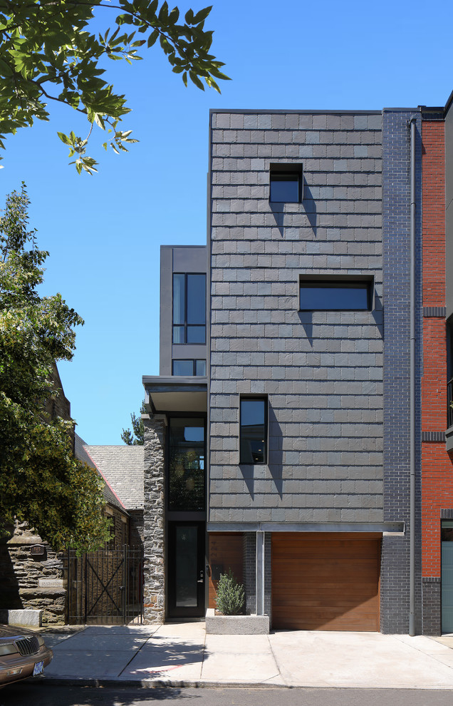 This is an example of a large modern three-storey grey townhouse exterior in Philadelphia with stone veneer, a flat roof and a mixed roof.