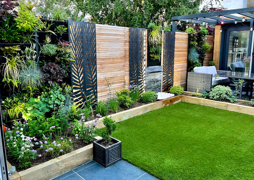 Photo of a mid-sized modern backyard partial sun garden for summer in Other with a vertical garden.