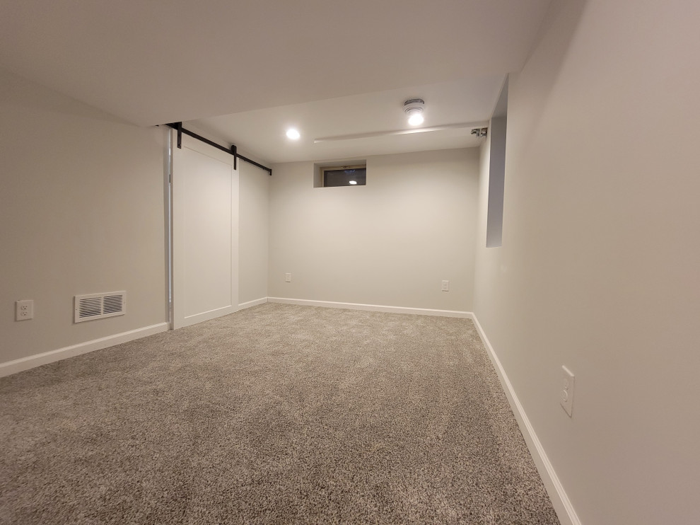 Exemple d'une chambre tendance de taille moyenne avec un mur gris et un sol gris.