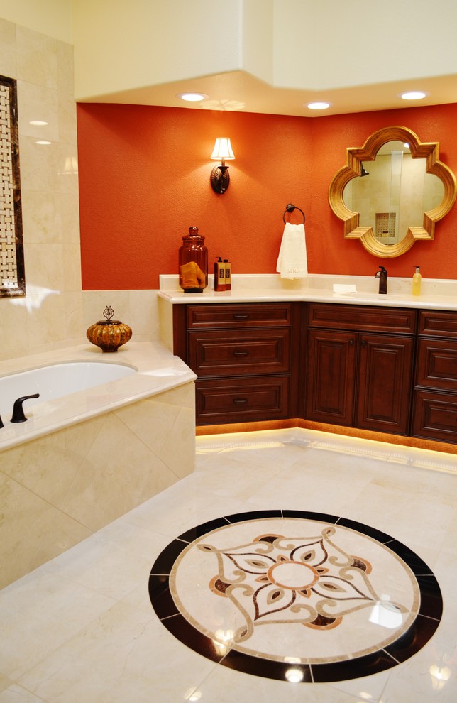 Photo of a large traditional master bathroom in Phoenix with an undermount sink, raised-panel cabinets, dark wood cabinets, marble benchtops, an undermount tub, a double shower, a bidet, beige tile, stone tile, orange walls and porcelain floors.