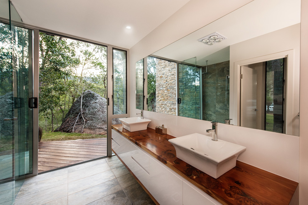 Inspiration for a transitional master bathroom in Brisbane with white cabinets and wood benchtops.