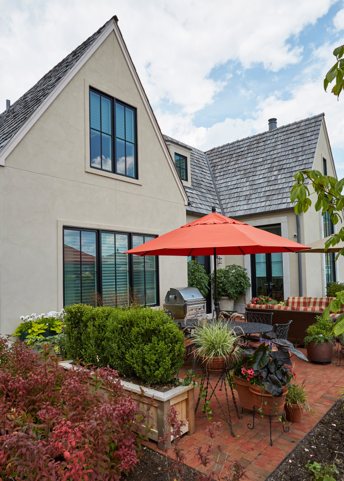 Esempio di un patio o portico country di medie dimensioni e dietro casa con un giardino in vaso, pavimentazioni in mattoni e nessuna copertura