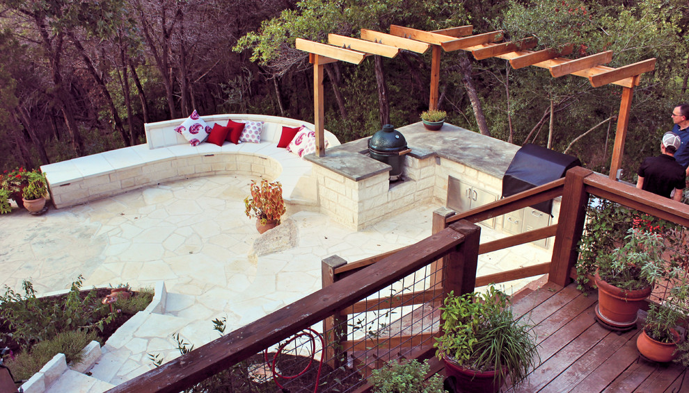 Mid-sized contemporary backyard patio in Austin with an outdoor kitchen, natural stone pavers and a pergola.