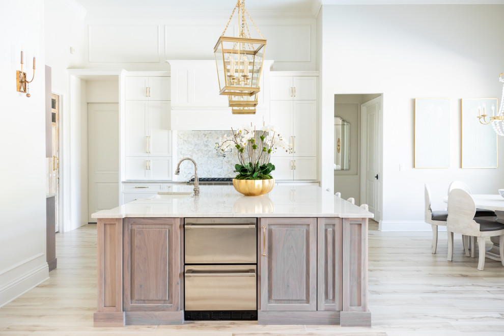 Large transitional porcelain tile and beige floor kitchen photo in Orlando with a farmhouse sink, recessed-panel cabinets, white cabinets, quartzite countertops, multicolored backsplash, marble backsplash, stainless steel appliances, an island and beige countertops