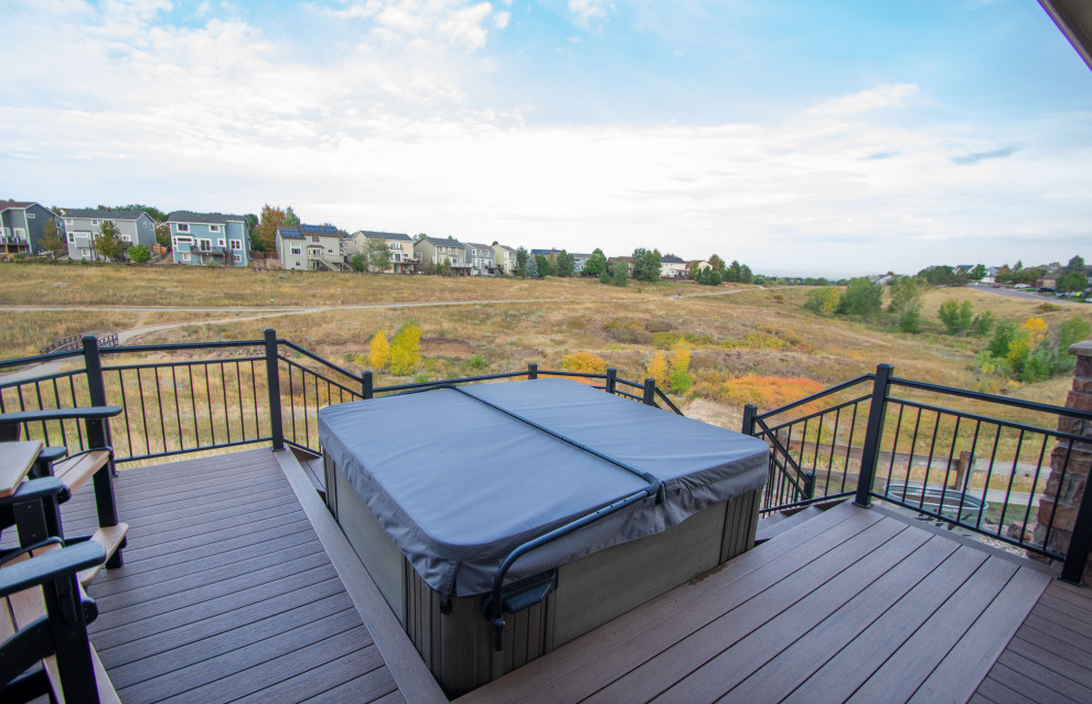 This is an example of a mid-sized transitional backyard and first floor deck in Denver with a fire feature, a roof extension and metal railing.