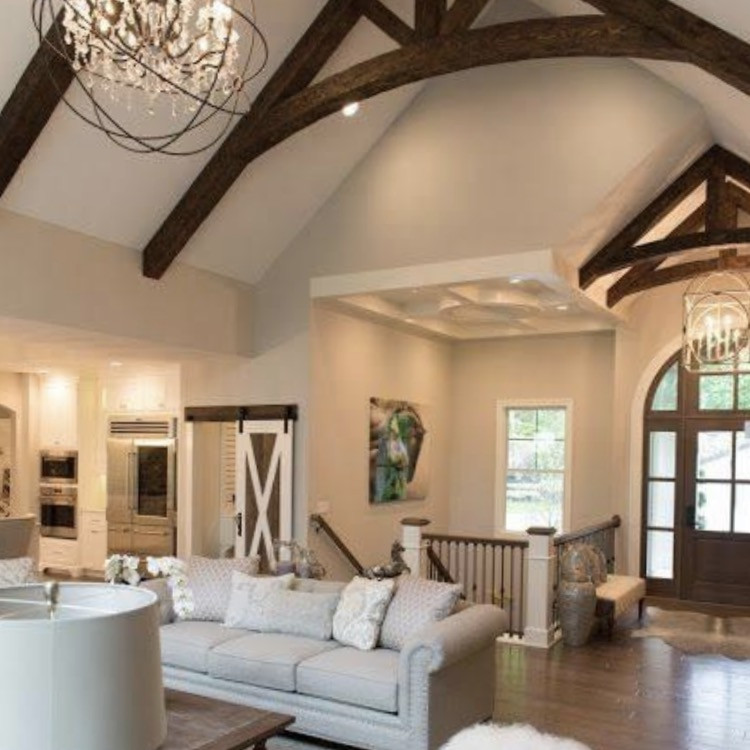 Expansive classic formal open plan living room in Surrey with white walls, painted wood flooring, a two-sided fireplace, a stone fireplace surround, a built-in media unit, brown floors, a timber clad ceiling and wallpapered walls.