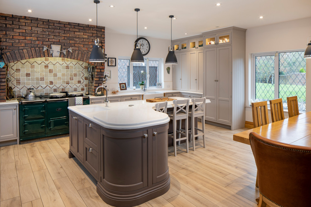 Photo of a large transitional l-shaped eat-in kitchen in Dublin with an undermount sink, shaker cabinets, grey cabinets, multi-coloured splashback, coloured appliances, medium hardwood floors, with island, beige floor and white benchtop.