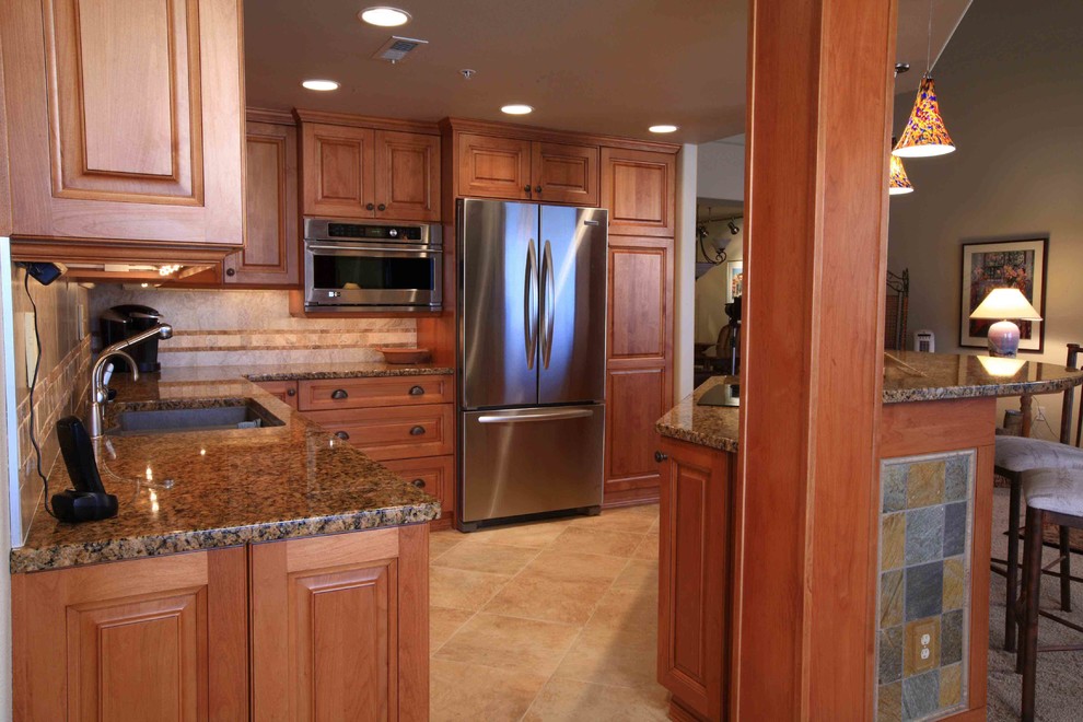 Inspiration for a large transitional l-shaped ceramic tile eat-in kitchen remodel in Seattle with an undermount sink, medium tone wood cabinets, granite countertops, beige backsplash, ceramic backsplash, stainless steel appliances and an island