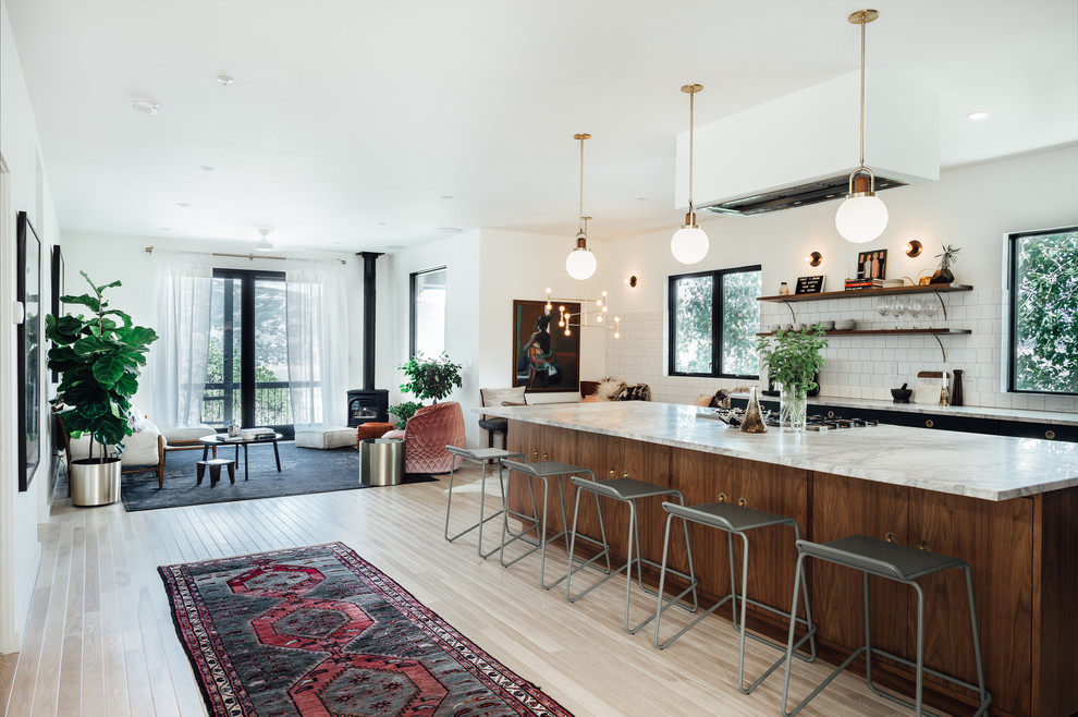 This is an example of a large eclectic l-shaped open plan kitchen in Salt Lake City with a drop-in sink, flat-panel cabinets, green cabinets, marble benchtops, white splashback, ceramic splashback, coloured appliances, light hardwood floors and with island.