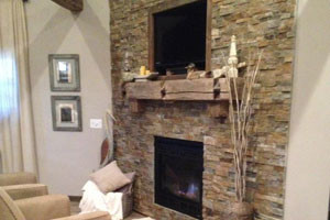 Home design - transitional home design idea with white walls, a standard fireplace, a stone fireplace and a concealed tv