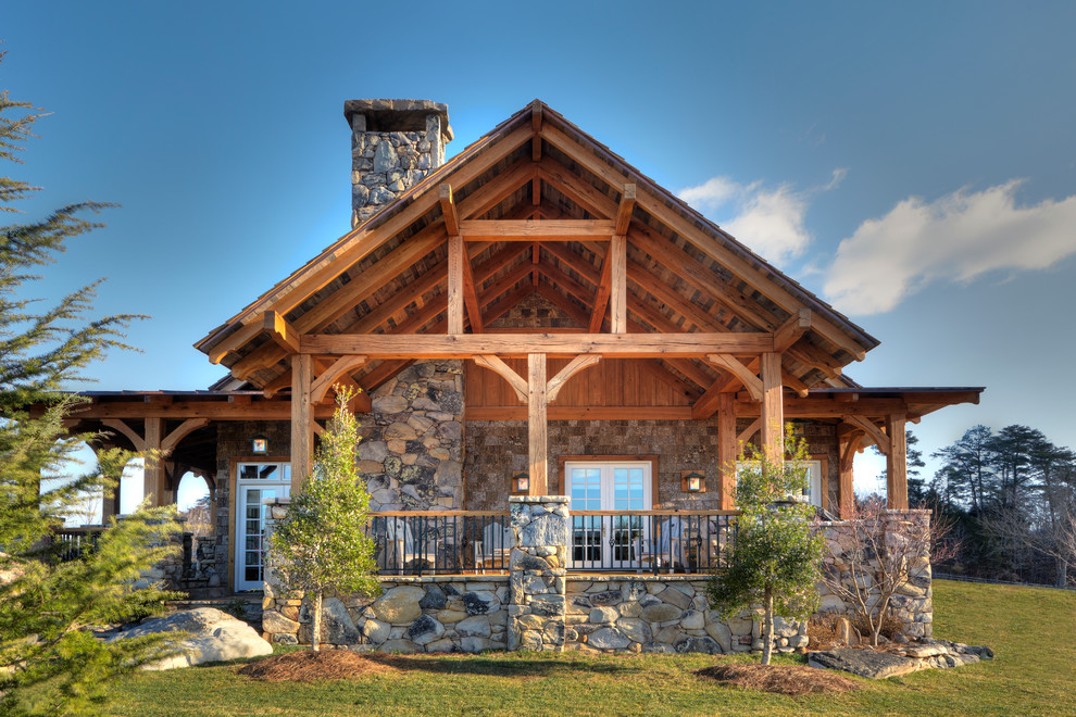 Example of a large mountain style gray two-story stone exterior home design
