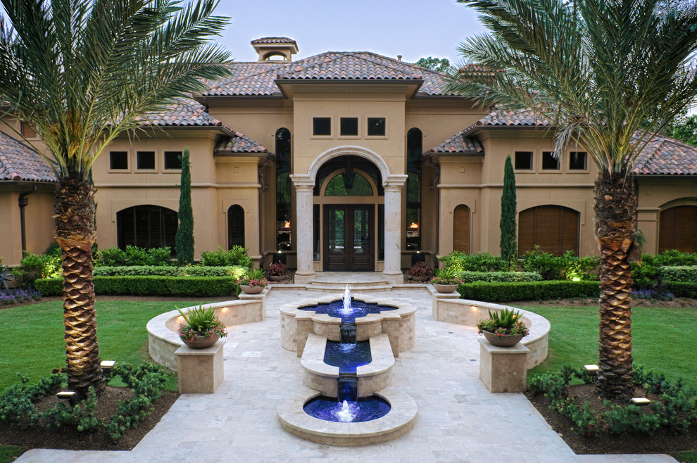 Design ideas for a large mediterranean front yard custom-shaped pool in Houston with a water feature and natural stone pavers.