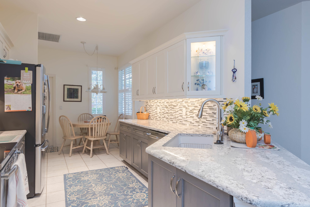 Eat-in kitchen - mid-sized transitional galley ceramic tile and white floor eat-in kitchen idea with an undermount sink, shaker cabinets, gray cabinets, quartz countertops, gray backsplash, glass tile backsplash and stainless steel appliances