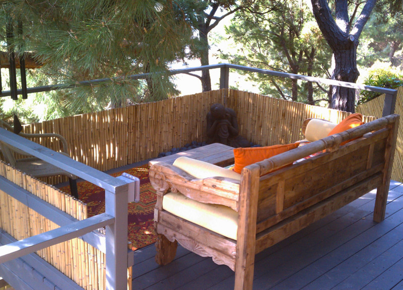 This is an example of a small tropical backyard deck in Los Angeles with no cover.