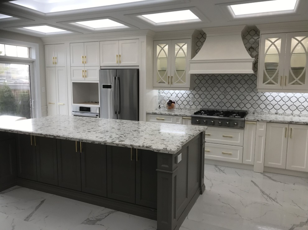 Large transitional single-wall kitchen in Toronto with recessed-panel cabinets, white cabinets, granite benchtops, grey splashback, marble splashback, stainless steel appliances, marble floors, with island, grey floor and grey benchtop.