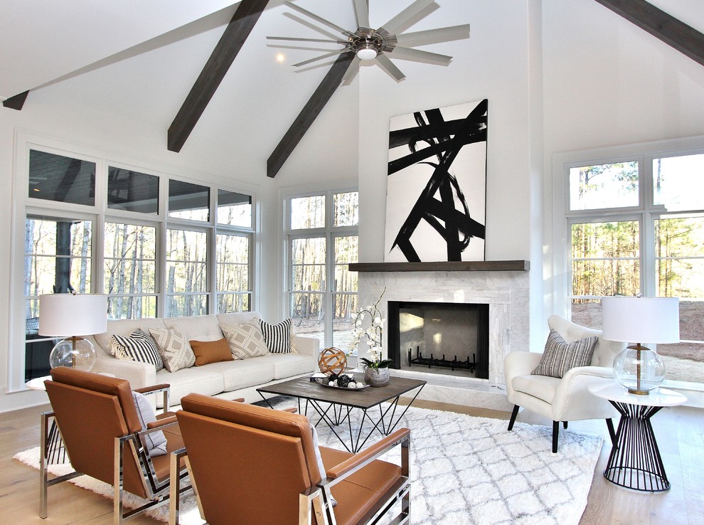 Contemporary open concept living room in Atlanta with white walls, medium hardwood floors, a standard fireplace and brown floor.