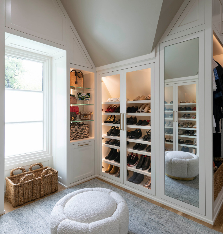 Design ideas for a large gender neutral walk-in wardrobe in Dallas with shaker cabinets, white cabinets, light hardwood flooring, brown floors and a vaulted ceiling.
