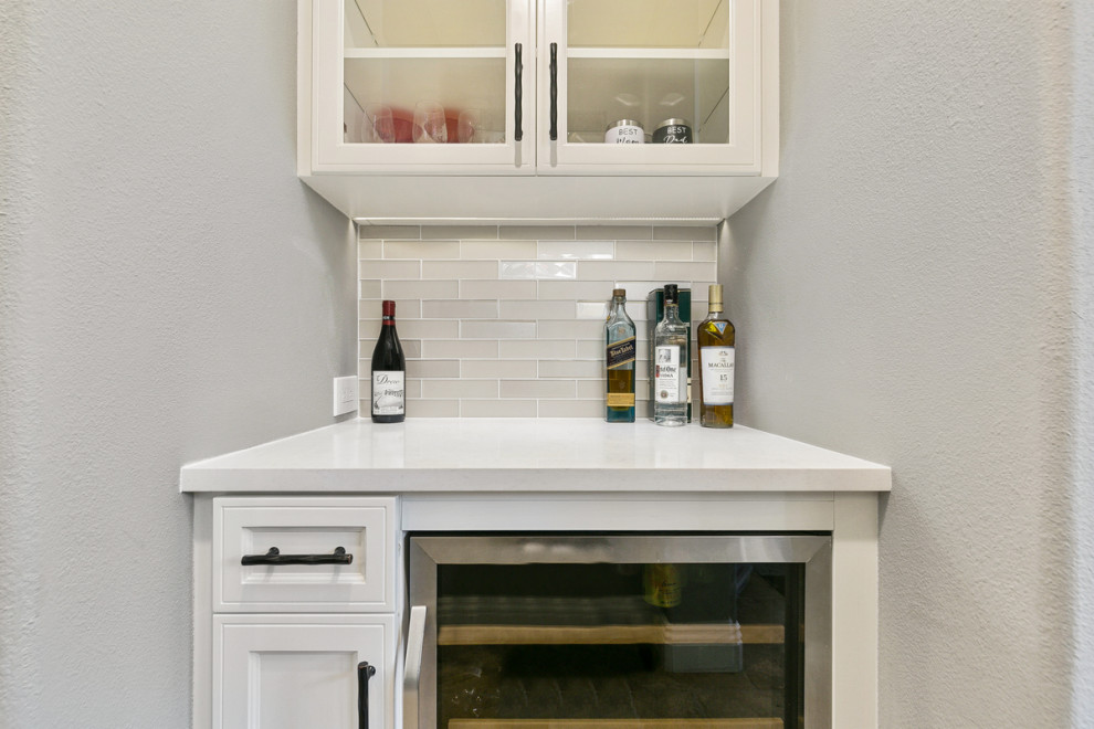 Example of a huge transitional u-shaped travertine floor and beige floor open concept kitchen design in Orange County with a single-bowl sink, shaker cabinets, white cabinets, quartz countertops, multicolored backsplash, stone tile backsplash, stainless steel appliances, an island and white countertops