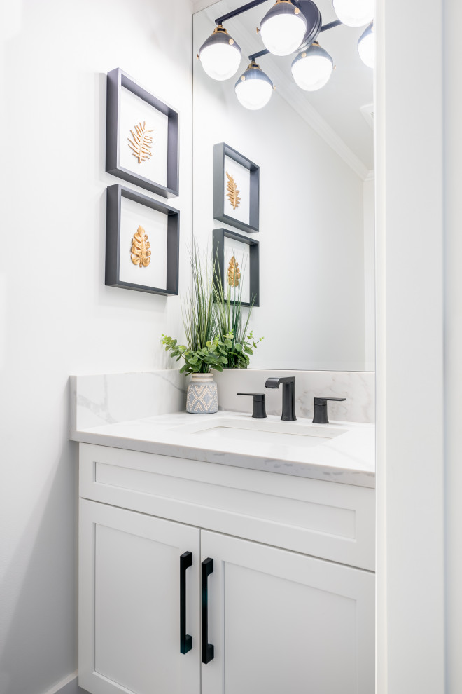 Photo of a small country powder room in Vancouver with shaker cabinets, white cabinets, a one-piece toilet, white walls, medium hardwood floors, a drop-in sink, engineered quartz benchtops, beige floor, white benchtops and a built-in vanity.