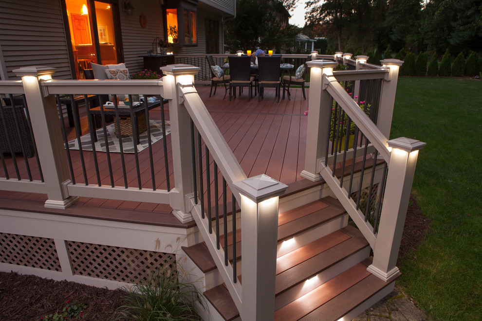 This is an example of a large arts and crafts backyard deck in Boston with a fire feature and no cover.