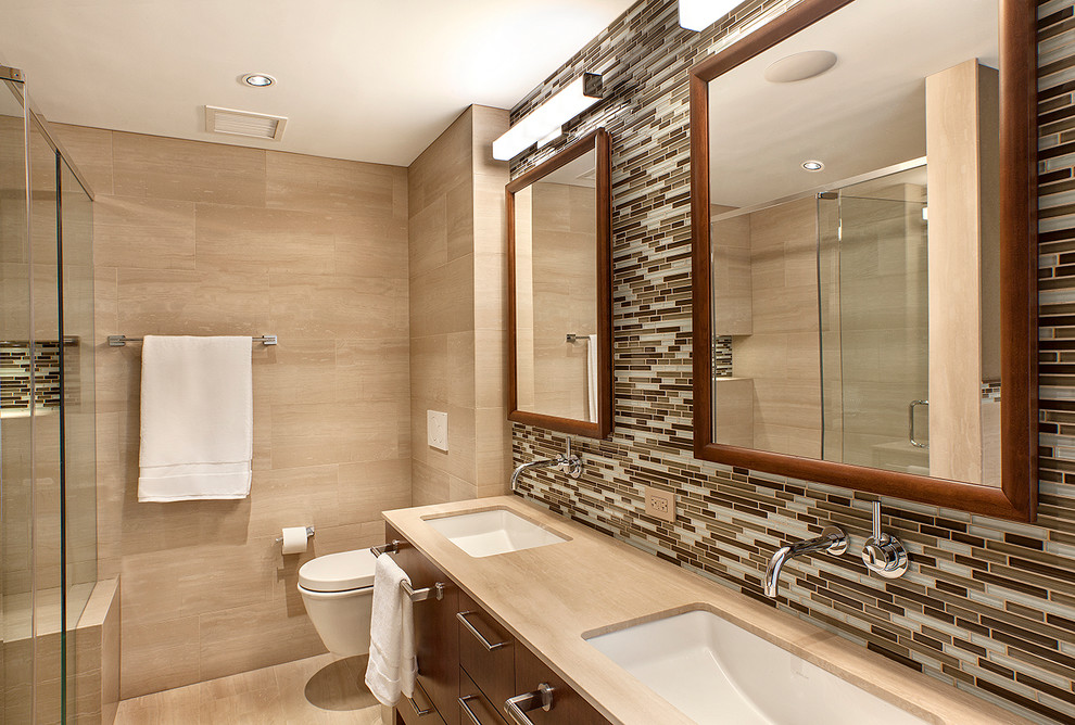 Design ideas for a large modern master bathroom in Chicago with an undermount sink, flat-panel cabinets, dark wood cabinets, onyx benchtops, an undermount tub, an alcove shower, a wall-mount toilet, beige tile, stone tile, beige walls and marble floors.