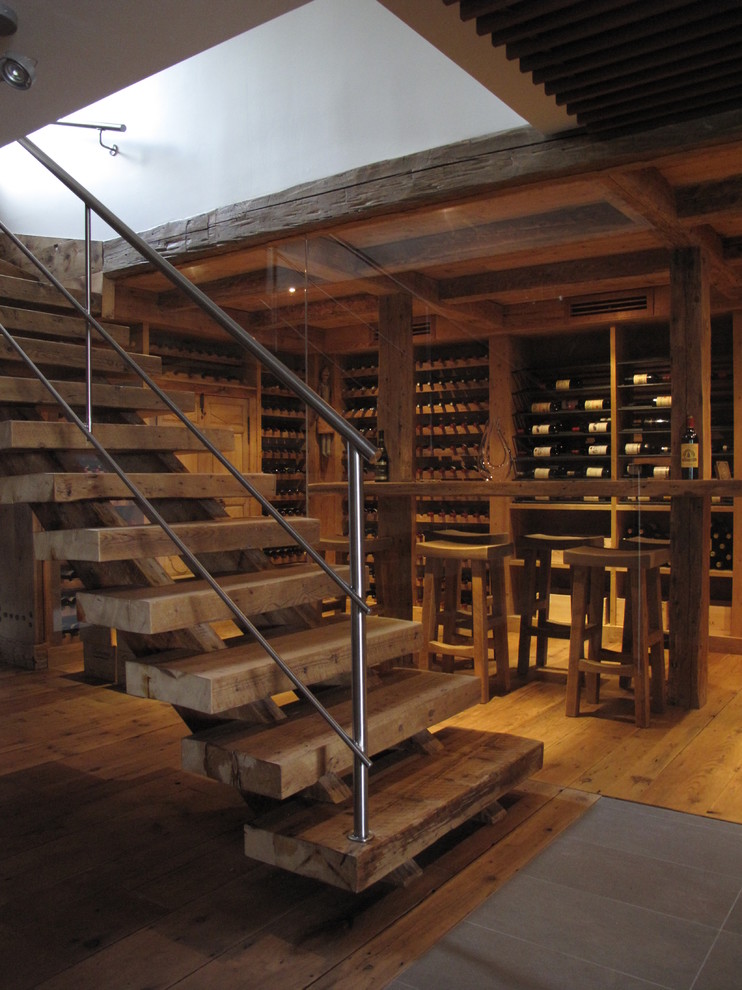 This is an example of a country wine cellar in Montreal with medium hardwood floors, storage racks and yellow floor.