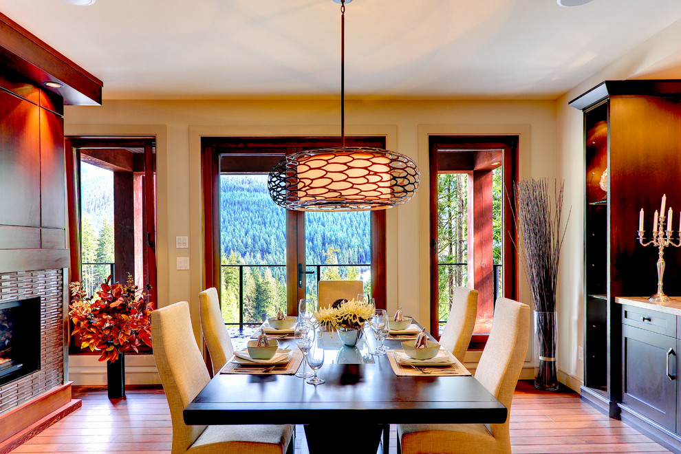 Contemporary dining room in Vancouver with beige walls, medium hardwood floors, a standard fireplace and a tile fireplace surround.