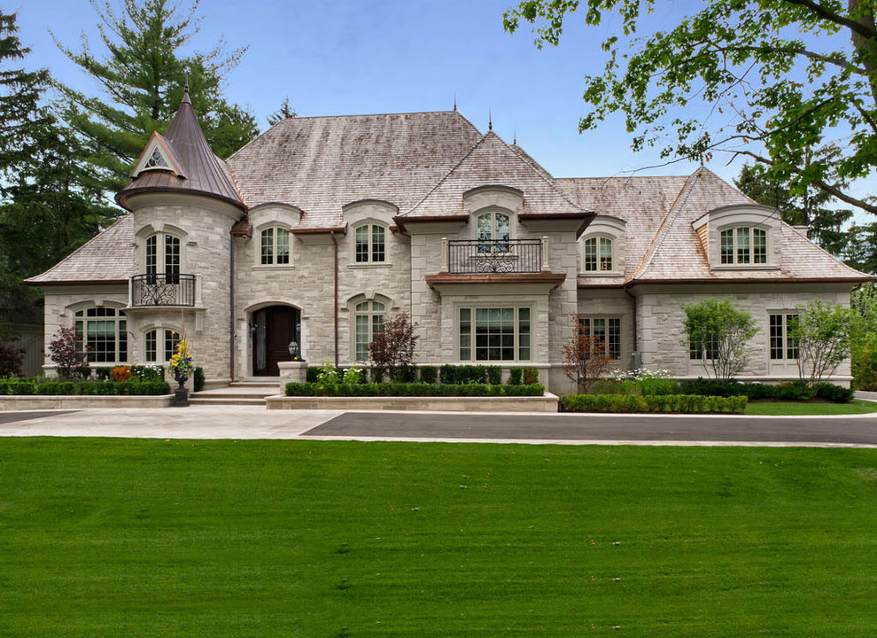 Photo of a large traditional exterior in Toronto with stone veneer and a hip roof.