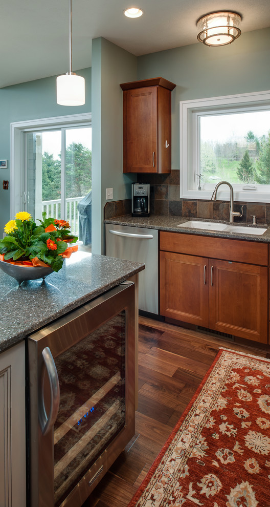 Open concept kitchen - mid-sized transitional l-shaped medium tone wood floor open concept kitchen idea with an undermount sink, shaker cabinets, medium tone wood cabinets, quartzite countertops, gray backsplash, stone tile backsplash, stainless steel appliances, blue walls and an island