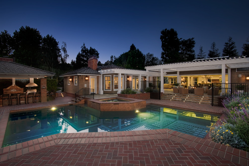 Expansive traditional backyard custom-shaped pool in San Diego with a hot tub.