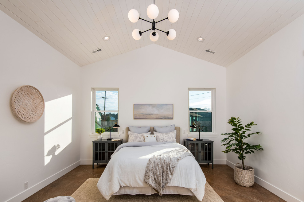 Large master bedroom in Portland with concrete flooring, brown floors and white walls.