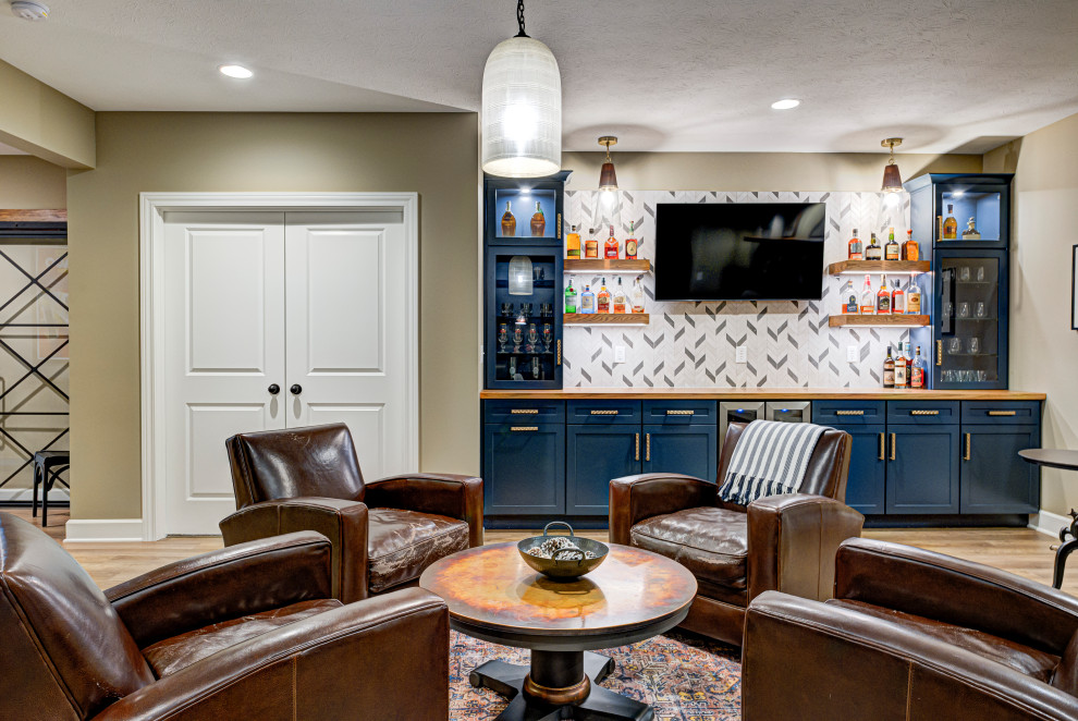 Design ideas for a contemporary home bar in Indianapolis with shaker cabinets, blue cabinets, wood benchtops, multi-coloured splashback, light hardwood floors, beige floor, beige benchtop and ceramic splashback.