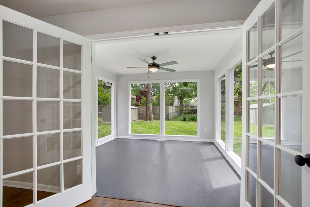 This is an example of a mid-sized modern sunroom in Kansas City with vinyl floors, a standard ceiling and black floor.