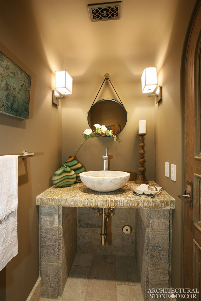Inspiration for a mid-sized mediterranean powder room in Toronto with beige tile, limestone floors, a console sink and limestone benchtops.