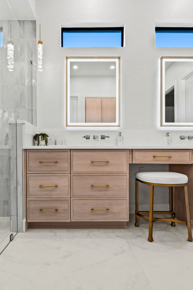 Walk-in shower - transitional master gray tile and porcelain tile porcelain tile, white floor and double-sink walk-in shower idea with shaker cabinets, light wood cabinets, a two-piece toilet, white walls, an undermount sink, quartz countertops, white countertops, a niche and a built-in vanity
