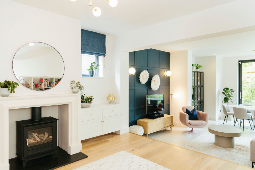 Exemple d'un grand salon ouvert avec une salle de réception, un mur bleu, sol en béton ciré, un poêle à bois, un manteau de cheminée en plâtre, un téléviseur indépendant, un sol gris et un mur en parement de brique.