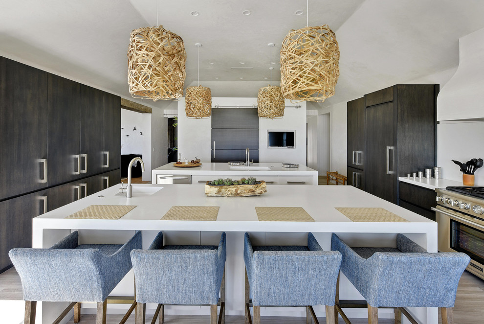 This is an example of a contemporary u-shaped separate kitchen in Jacksonville with an integrated sink, flat-panel cabinets, dark wood cabinets, stainless steel appliances, multiple islands and white benchtop.