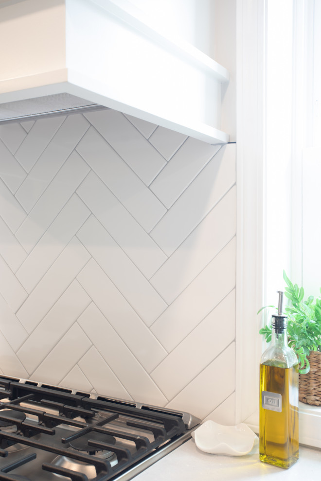 Kitchen - transitional vinyl floor kitchen idea with shaker cabinets, white cabinets, quartz countertops, white backsplash, porcelain backsplash, stainless steel appliances and white countertops