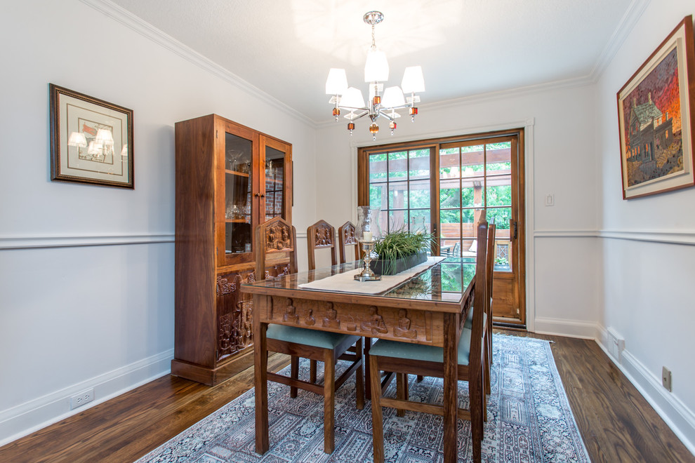 This is an example of a mid-sized eclectic separate dining room in Toronto with white walls, medium hardwood floors and no fireplace.